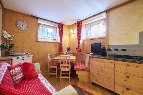 ein Wohnzimmer mit einer Küche und einem Tisch mit einem Sofa in der Unterkunft L'appartamentino del cuore in Bormio