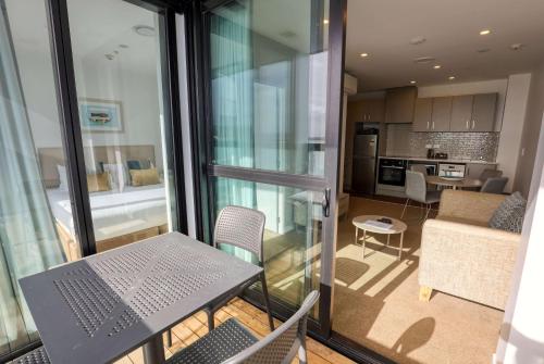 a balcony with a table and chairs and a kitchen at Ramada Suites By Wyndham Victoria Street West in Auckland