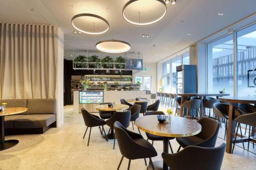 a restaurant with tables and chairs and a bar at Wyndham Garden Christchurch Kilmore Street in Christchurch