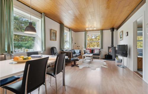 un soggiorno con tavolo e sedie di Three-Bedroom Holiday Home In Romo a Tagholm