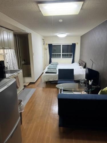 a hotel room with a bed and a living room at カサデューク平岸45 in Toyohira