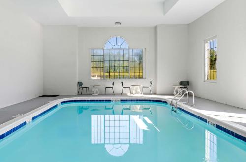 a swimming pool with blue water in a white room at Spark by Hilton Winston-Salem University in Winston-Salem