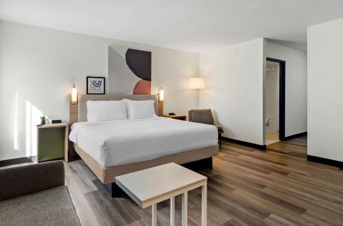 a hotel room with a bed and a chair at Spark by Hilton Winston-Salem University in Winston-Salem