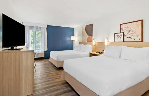 a hotel room with two beds and a flat screen tv at Spark by Hilton Winston-Salem University in Winston-Salem