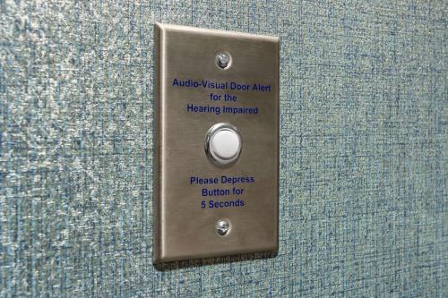 a metal door tag with a button on a wall at Home2 Suites By Hilton Owatonna in Owatonna