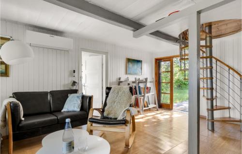 a living room with a black couch and a table at Awesome Home In Stege With Wifi in Stege