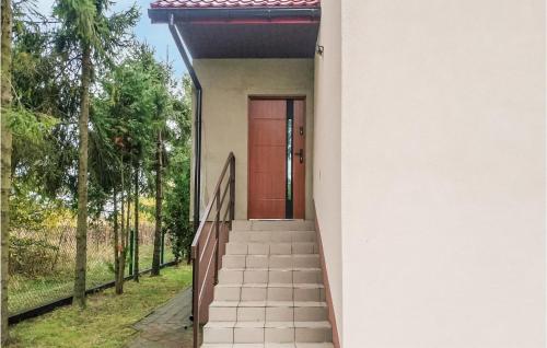 a red door on a white house with stairs at 3 Bedroom Awesome Apartment In Klucze in Klucze