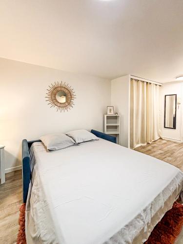 une chambre avec un grand lit avec un miroir au mur dans l'établissement Le Cocon Rochelais, à La Rochelle