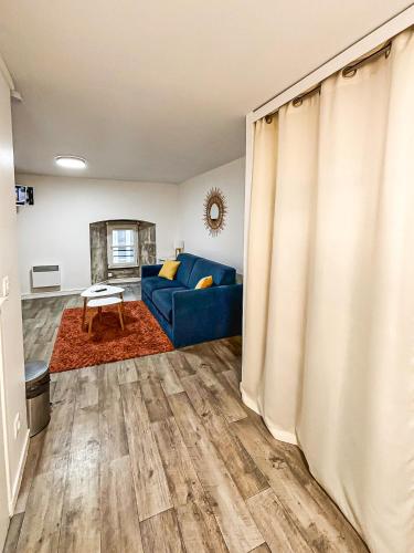 a living room with a blue couch and a table at Le Cocon Rochelais in La Rochelle