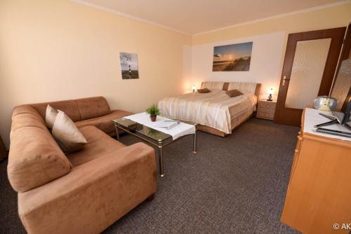 a living room with a couch and a bed at Haus "Luv und Lee" Appartement LEE06 in Döse