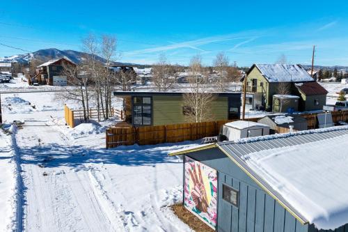 a house in the snow with snow covered roofs at Luxury Modern Tiny Home in Downtown Fraser in Fraser