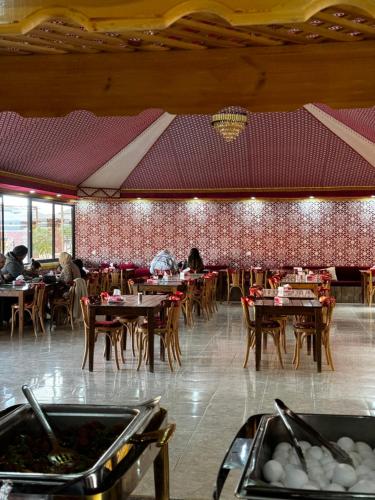 a restaurant with tables and chairs and people sitting at tables at Rum Angel Camp in Wadi Rum