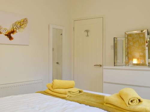 a bedroom with a bed with yellow towels on it at Bridge House in Loftus