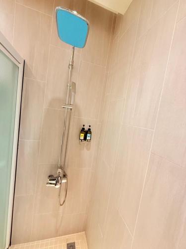 a shower with a blue shower head in a bathroom at Michi Hotel - Zhongli in Zhongli