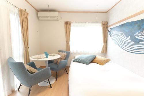 a bedroom with a bed and a table and chairs at Domire Setagaya by Tranova in Tokyo