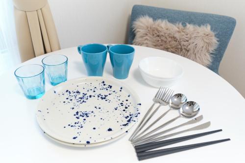 a white table with a plate and glasses on it at Domire Setagaya by Tranova in Tokyo