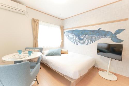 a room with a bed and a tv and a table at Domire Setagaya by Tranova in Tokyo