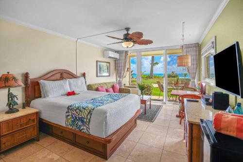 a bedroom with a bed and a flat screen tv at Islander on the Beach 154 in Kapaa