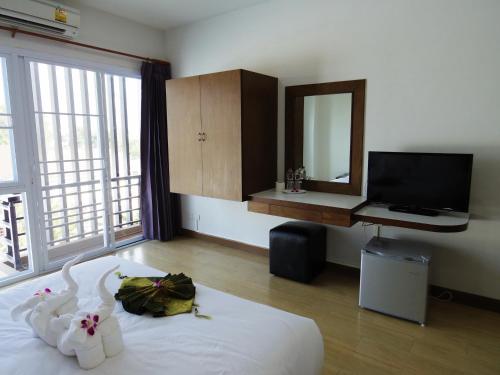 a bedroom with a bed with a mirror and a television at The SR Residence Lampang in Lampang