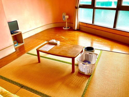 a living room with a coffee table in a room at Hostel Hakuseiso in Naha