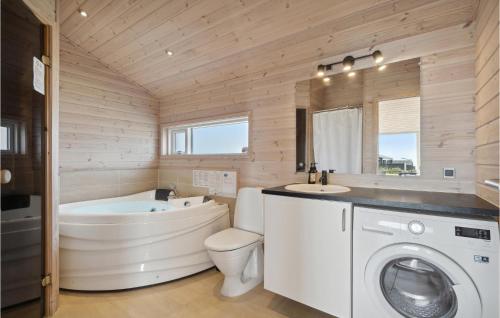 a bathroom with a tub sink and a washing machine at Four-Bedroom Holiday Home In Haderslev in Haderslev