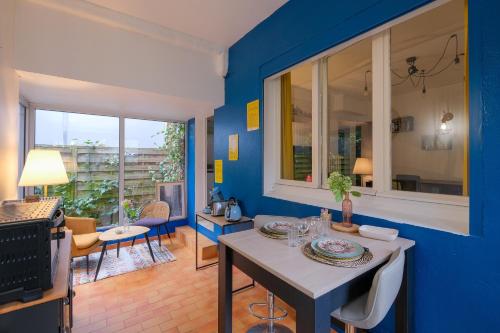 une salle à manger avec des murs bleus et une table dans l'établissement La terrasse de M.Hulot - 1 chambre, à Saint-Nazaire