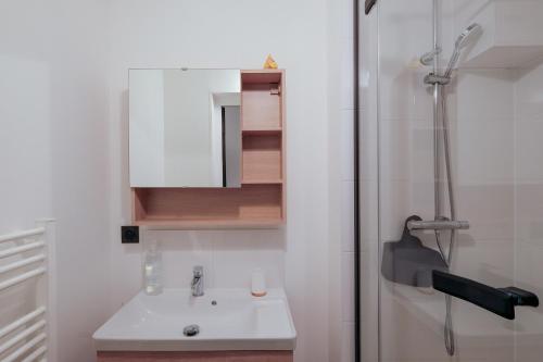 une salle de bain avec un lavabo et une douche dans l'établissement La terrasse de M.Hulot - 1 chambre, à Saint-Nazaire