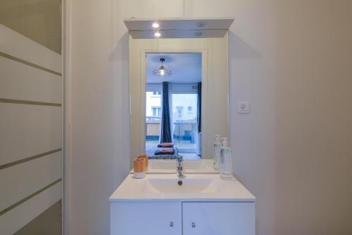 une salle de bain avec un lavabo et un miroir dans l'établissement Le Studio de M.Hulot - Climatisé proche plage, à Saint-Nazaire