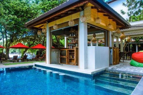 a bar next to a swimming pool next to a house at Surf Sea Breeze in Mirissa