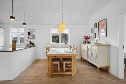 a kitchen and dining room with a wooden table and chairs at Sommerhus i Arrild Ferieby nær Vesterhavet in Arrild