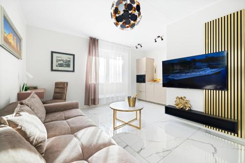 a living room with a couch and a tv on a wall at F-Apartments - River view, Contactless in Tartu