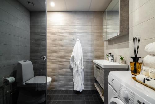 a bathroom with a toilet and a sink at F-Apartments - River view, Contactless in Tartu