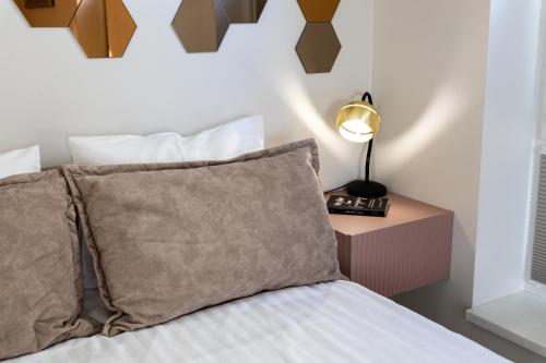 a bedroom with a bed and a nightstand with a lamp at F-Apartments - River view, Contactless in Tartu