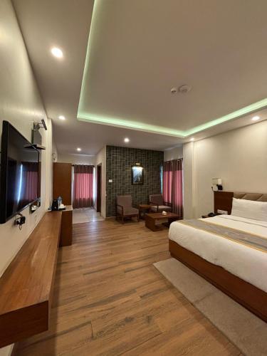 a hotel room with a bed and a living room at Palette 823 Hotel Ichchha in Simara