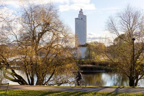 a person riding a bike next to a river at F-Apartments - River view, Contactless in Tartu