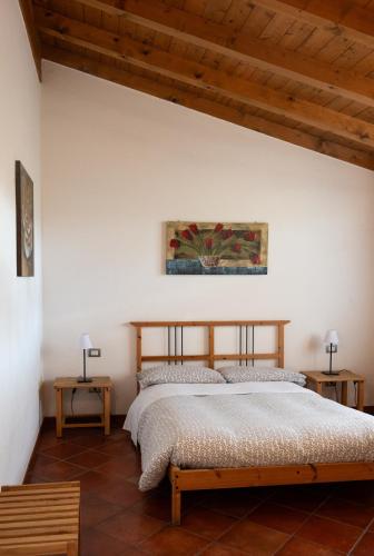 a bedroom with a bed in a room with wooden ceilings at Agri Village Pavia in Certosa di Pavia