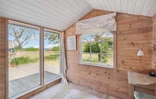 a wooden cabin with a window and a porch at Awesome Home In Svaneke With Wifi in Svaneke