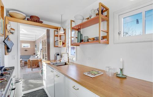 a kitchen with white cabinets and a wooden counter top at Awesome Home In Svaneke With Wifi in Svaneke