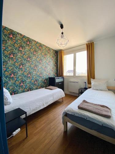 une chambre avec deux lits et un tableau au mur dans l'établissement Centre ville Dijon Wilson *Chez Charles* 2Ch, à Dijon