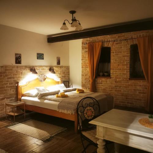 a bedroom with a bed and a brick wall at Kúria Apartman Private Wellness in Budapest