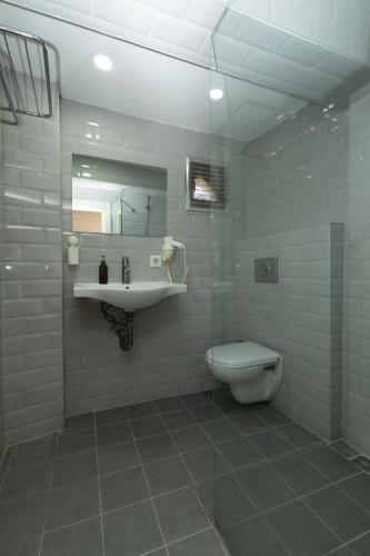 a bathroom with a sink and a toilet and a mirror at Deniz Pansiyon in İzmir