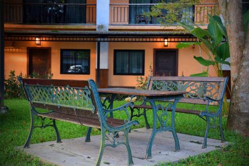 two benches and a table in front of a house at Chalicha Resort in Chumphon