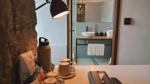 a desk with a lamp and a sink in a bathroom at Chill Roof Hotel in Taipei