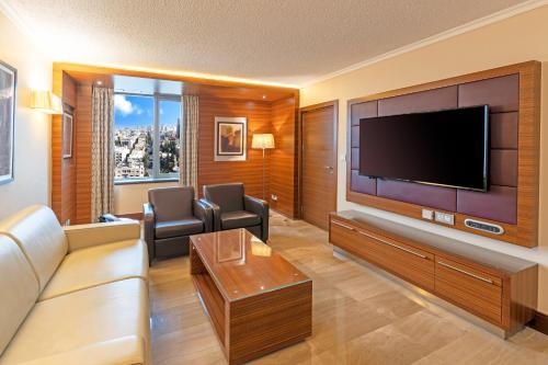 a living room with a large flat screen tv at Crowne Plaza Amman by IHG in Amman