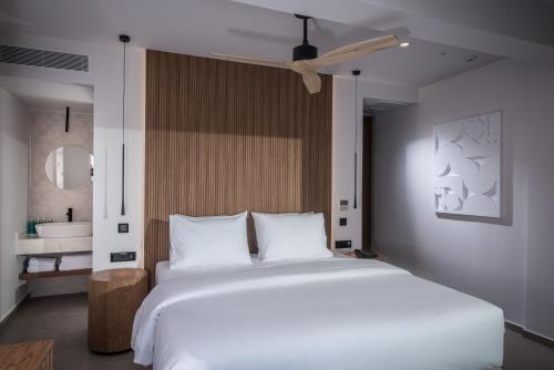 a bedroom with a large white bed and a bathroom at Noble Hotel & Suites - Adults Only in Gouves