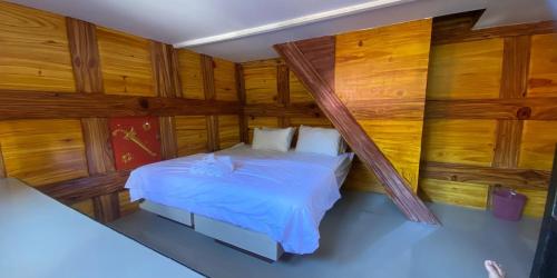 マカレにあるHotel Lallanganの木製の壁とベッドが備わるベッドルーム1室
