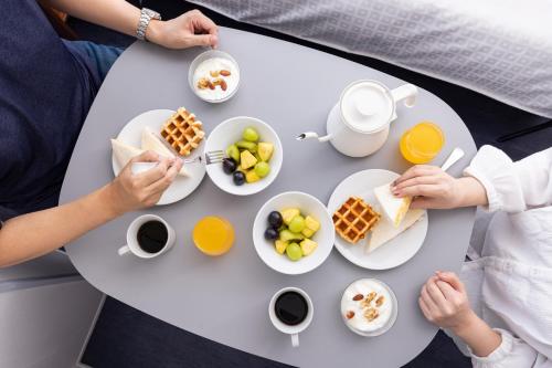 two people sitting at a table eating breakfast at Tokyu Stay Ikebukuro in Tokyo