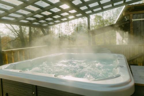 a bath tub with steam coming out of it at Shiva - Bohemian Homes in Studánka