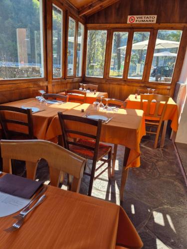 a restaurant with wooden tables and chairs and windows at Locanda Rocchetta-Premilcuore in Premilcuore