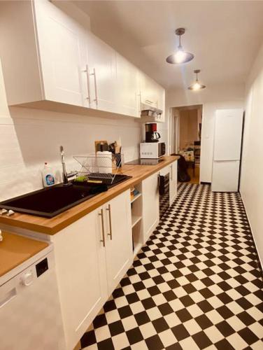 a kitchen with a black and white checkered floor at Gîte de la croix du Dan in Poligny